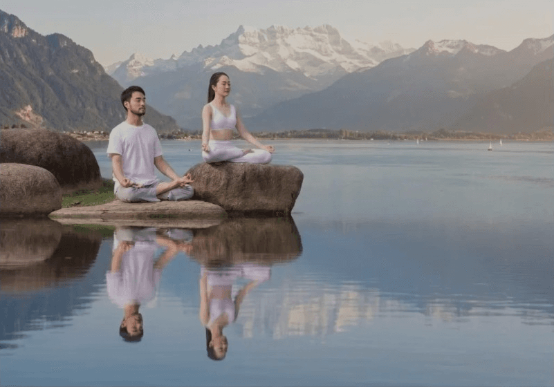 A calm lakeside meditation scene with mountain reflections, conveying quiet companionship and ease